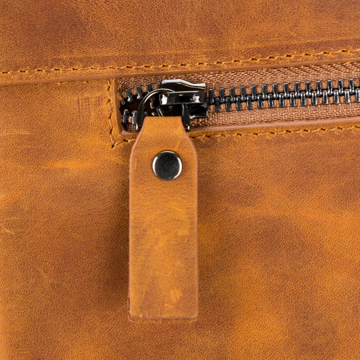 Close-up of a brown leather briefcase with a zipper