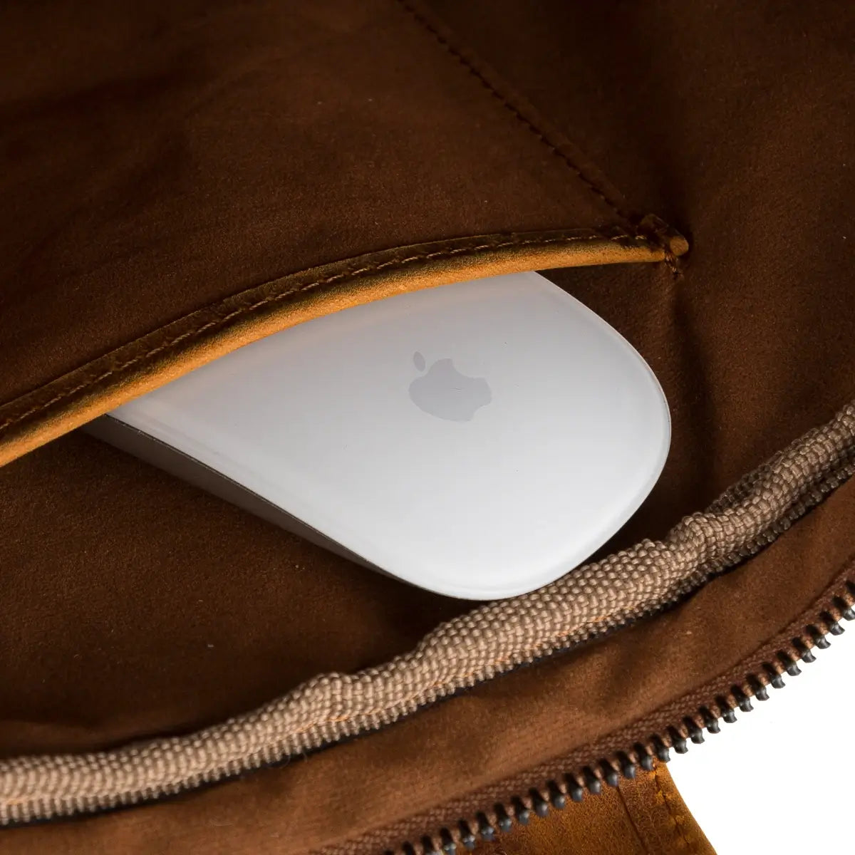 White Apple mouse inside a camel brown briefcase