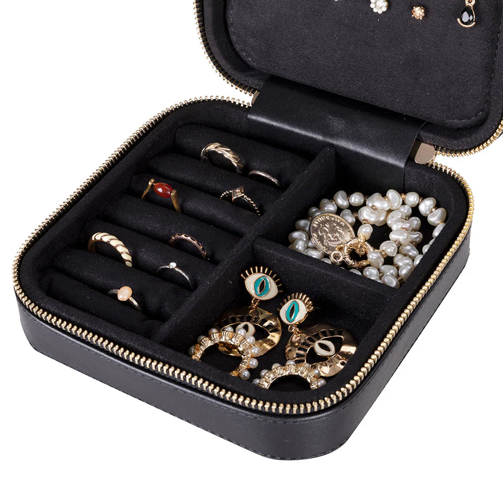 Black leather jewelry box with compartments holding various rings and a necklace.