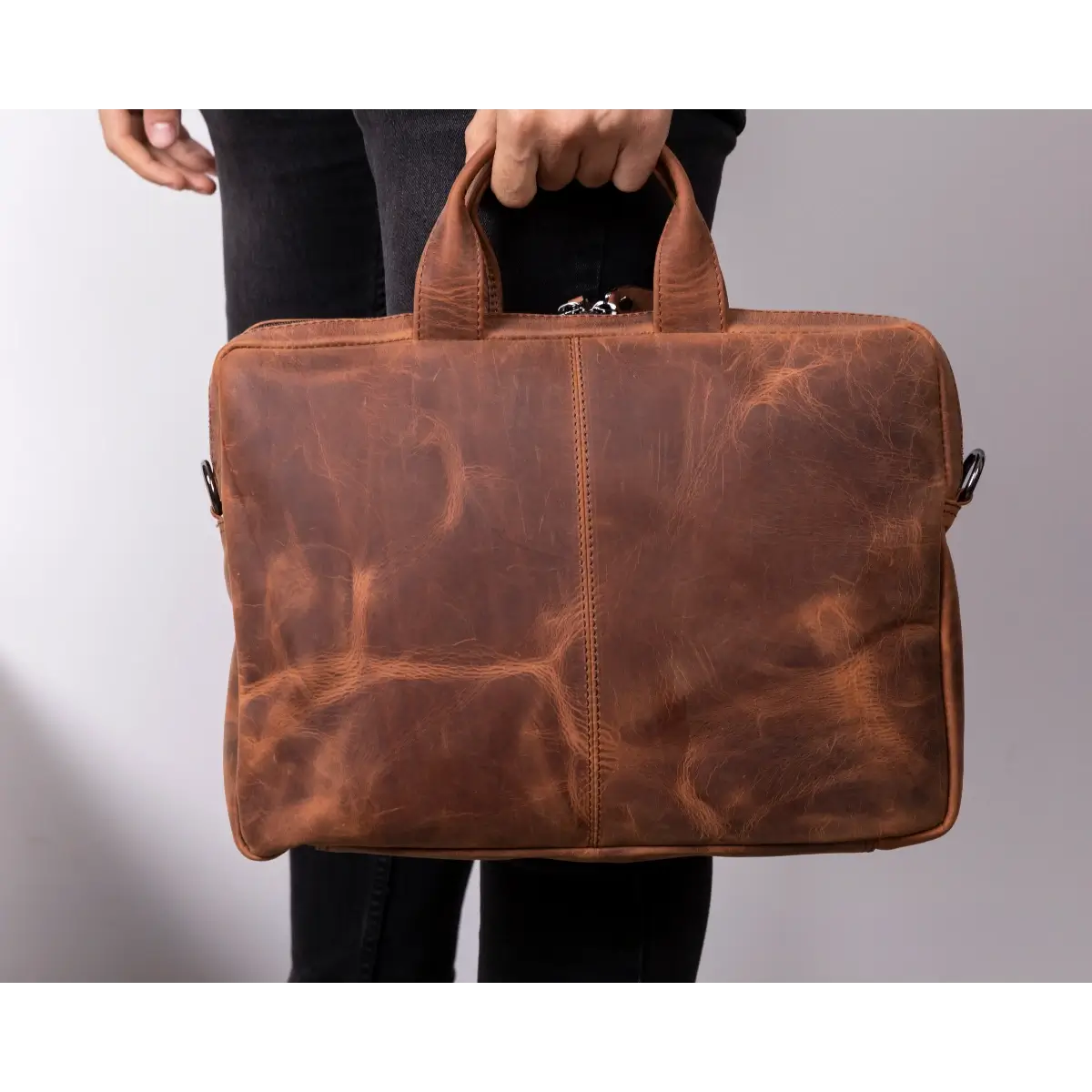 Brown leather briefcase held by a person